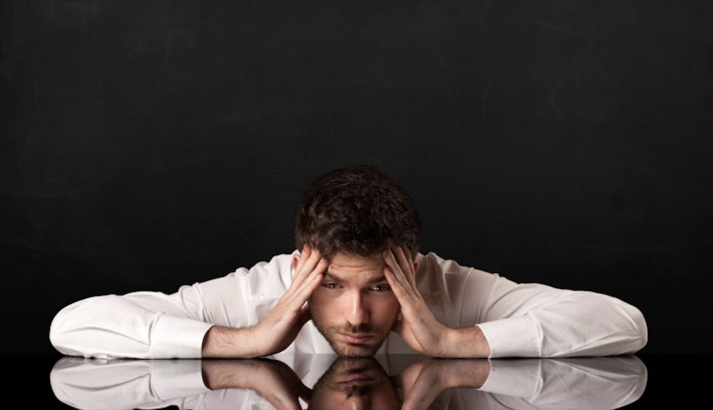 66fdb9ef36c97e4a1b8b5485 Manwithchinonblackshinydeskholdingheadinhands