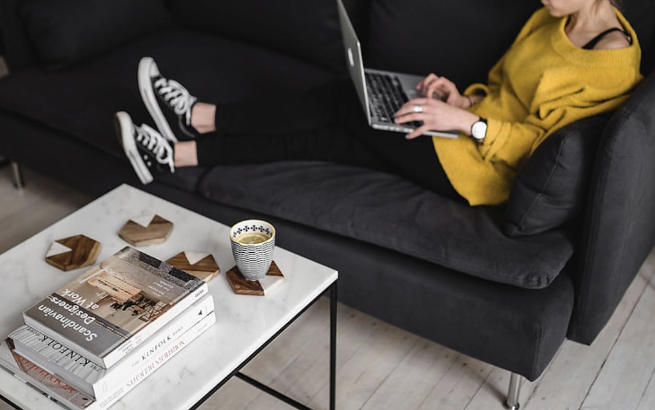 66fdbc7c3cabd9d208a69375 Youngwomansittingonsofaworkingonlaptopwithcoffee