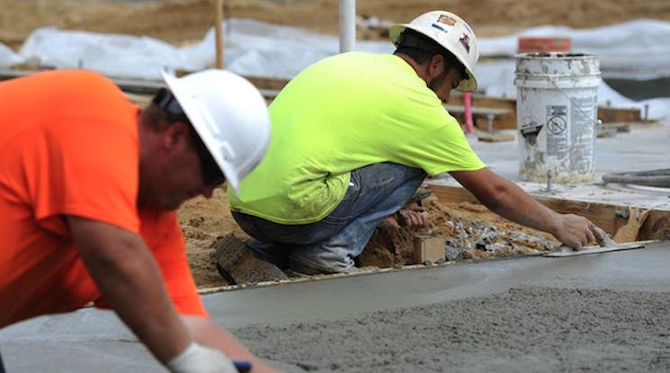 66fdc0a1de5fd1a25e5491c2 Workers20trowel20concrete20house20footingphoto20hu