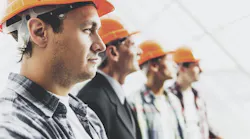 Close up. Engineers in Shirts and Orange Helmets By VadimGuzhva - Adobe Stock