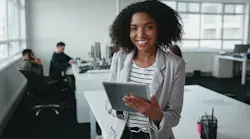 businesswoman holding digital tablet in hand looking at camera with colleague at background in office See Less By StratfordProductions - Adobe Stock