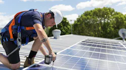 Solar panel technician with drill installing solar panels By Zstock - Adobe Stock
