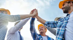 close up of builders in hardhats making high five By Syda Productions - Adobe Stock