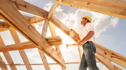 roofer builder working on roog structure of building on construction site By sculpies - Adobe Stock