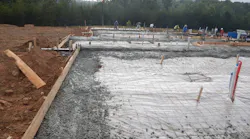 A concrete crew fills the footing form for a slab-on-grade home. The risk of pouring all of the footings first is that they will begin to set before the concrete for the slab arrives, usually resulting in cold joints. | Photos: courtesy IBACOS
