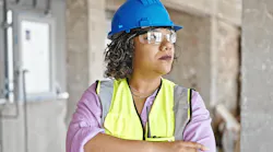 Woman in blue hard hat and yellow safety vest on construction jobsite