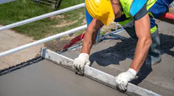 Construction worker leveling concrete on jobsite