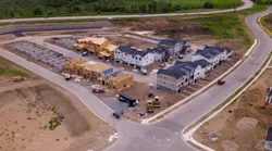 Aerial view of new housing development with homes at different stages of construction