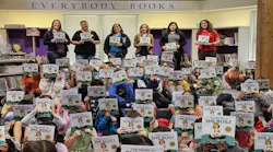 Students at Hazelwood Elementary in Edmonds, Wash., hold up their newly received 'House That She Built' books