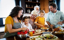 A family cooks together at a kitchen island A family cooks together at a kitchen island