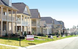 Pictured is a row of homes, and one home has a 'for sale' sign in the front yard with a secondary sign reading 'reduced.' Pictured is a row of homes, and one home has a 'for sale' sign in the front yard with a secondary sign reading 'reduced.'