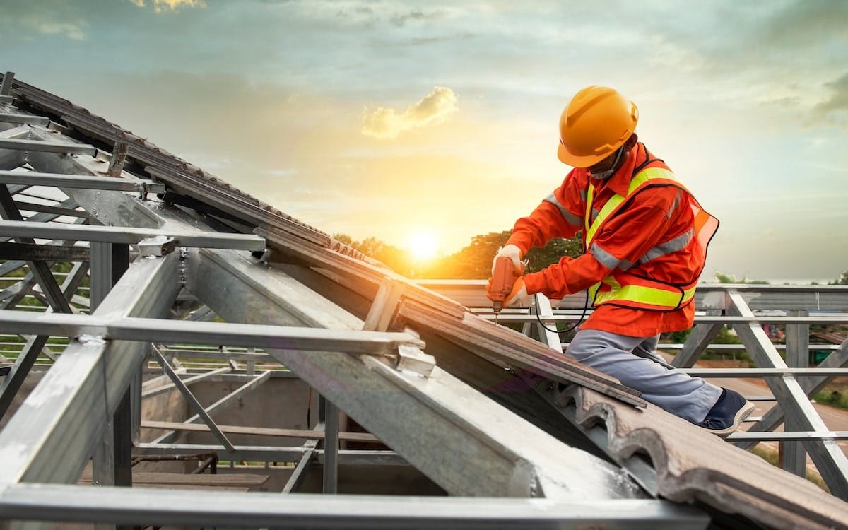 A construction worker works on a pitched roof