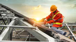 A construction worker works on a pitched roof