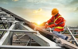 A construction worker works on a pitched roof A construction worker works on a pitched roof