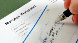 A closeup image of a hand writing out a check to a mortgage company