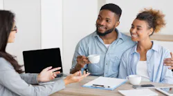 A Millennial couple speaks with a real estate agent about purchasing a home