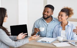 A Millennial couple speaks with a real estate agent about purchasing a home A Millennial couple speaks with a real estate agent about purchasing a home