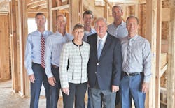Olthof Homes' management team standing in one of the company's homes at the framing stage Olthof Homes' management team standing in one of the company's homes at the framing stage