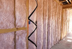 Fiberglass batts installed to insulate a home wall cavity Fiberglass batts installed to insulate a home wall cavity