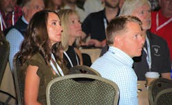 Danielle and Jesse Younger listening to presentation in crowded room Danielle and Jesse Younger listening to presentation in crowded room