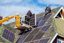 Workers putting solar panels onto roof Workers putting solar panels onto roof