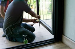 Person installing patio door hardware Person installing patio door hardware