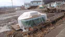 muddy jobsite with materials stored correctly off the ground and covered with plastic tarps muddy jobsite with materials stored correctly off the ground and covered with plastic tarps