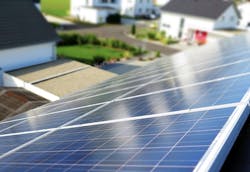 Solar panels on a house roof in a neighborhood that has a microgrid Solar panels on a house roof in a neighborhood that has a microgrid