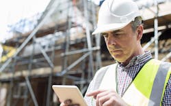 Man Using Build Tools Construction Management Software On Tablet Man Using Build Tools Construction Management Software On Tablet