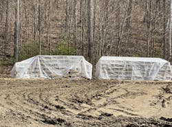 Lumber stacked and covered to protect it from weather on the jobsite. Lumber stacked and covered to protect it from weather on the jobsite.
