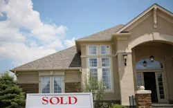 A house with a 'sold' sign in the yard A house with a 'sold' sign in the yard