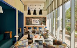 A lounge space with various seating areas and large windows A lounge space with various seating areas and large windows