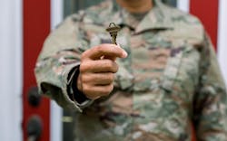 A man in a U.S. Army uniform holds up a key to a new home A man in a U.S. Army uniform holds up a key to a new home