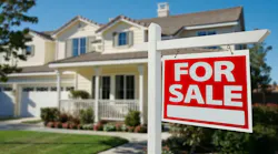 A home with a red 'For Sale' sign in the front yard