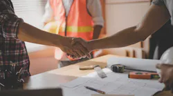 A worker and a homeowner shake hands, negotiating a job.