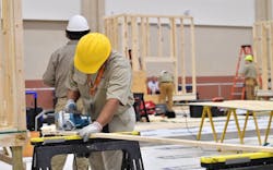 Students in hard hats work on a construction project at school Students in hard hats work on a construction project at school