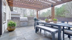 A covered patio with grill and dining area A covered patio with grill and dining area