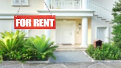 A single-family home sits in the background. In the foreground is a red sign reading 'For Rent.' A single-family home sits in the background. In the foreground is a red sign reading 'For Rent.'