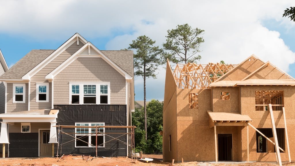 A newly built home sits next to one that is under construction