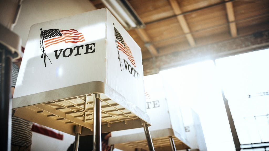 A row of voting booths with American flags on them