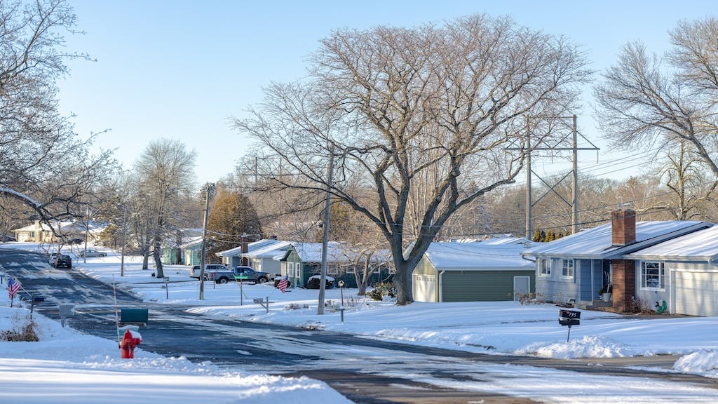 Residential street with homes covered in snow