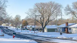 Residential street with homes covered in snow