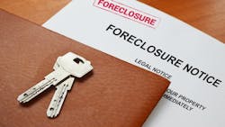 Closeup of a foreclosure notice with a leather folder and house key sitting on top Closeup of a foreclosure notice with a leather folder and house key sitting on top