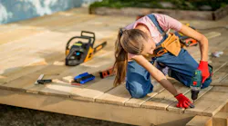 A woman carpenter works on a home decking project.