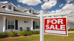 For sale sign in the front yard of a single-family home.