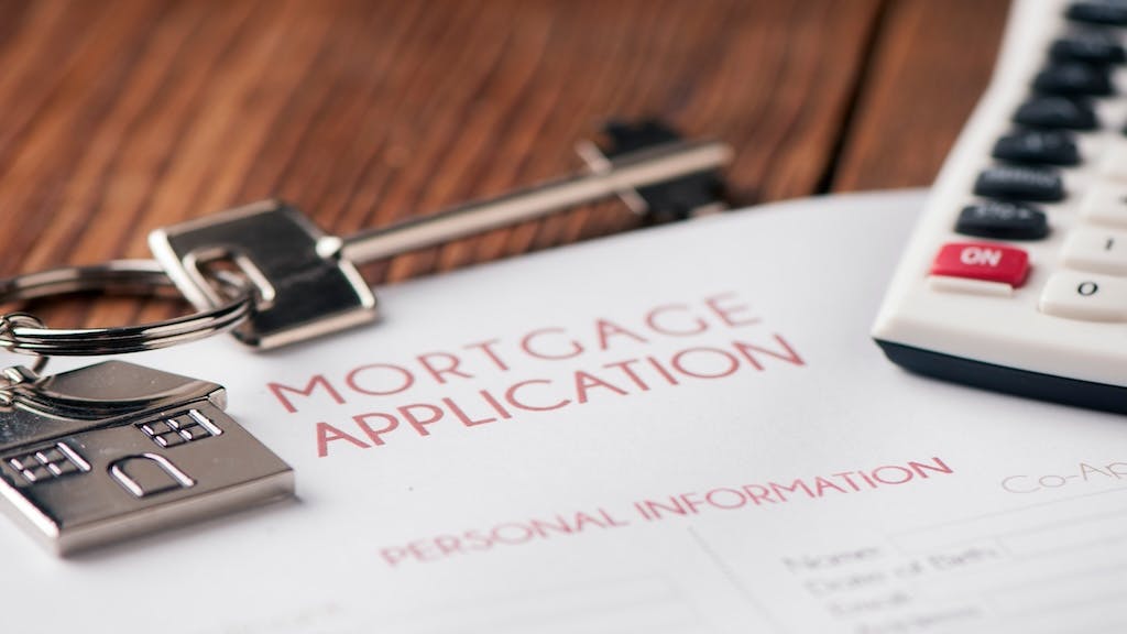 A mortgage application with a house key and calculator