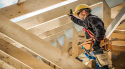 A contractor works on the roof of a house.