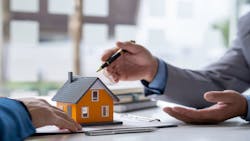 A real estate agent goes over the homebuying process with a potential buyer A real estate agent goes over the homebuying process with a potential buyer