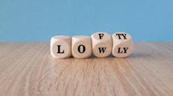 Wooden blocks with 'lowly' letters switching to 'lofty' indicate striving for higher goals. Wooden blocks with 'lowly' letters switching to 'lofty' indicate striving for higher goals.