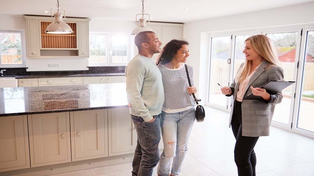 A real estate agent gives buyers a tour of a home.